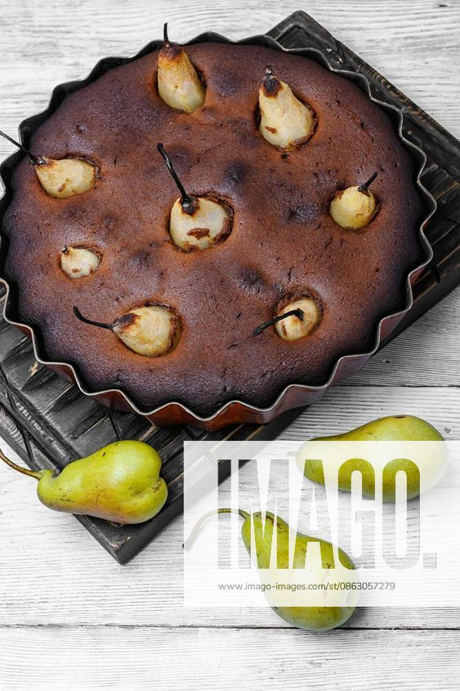 Autumn chocolate cake with whole pears on light background