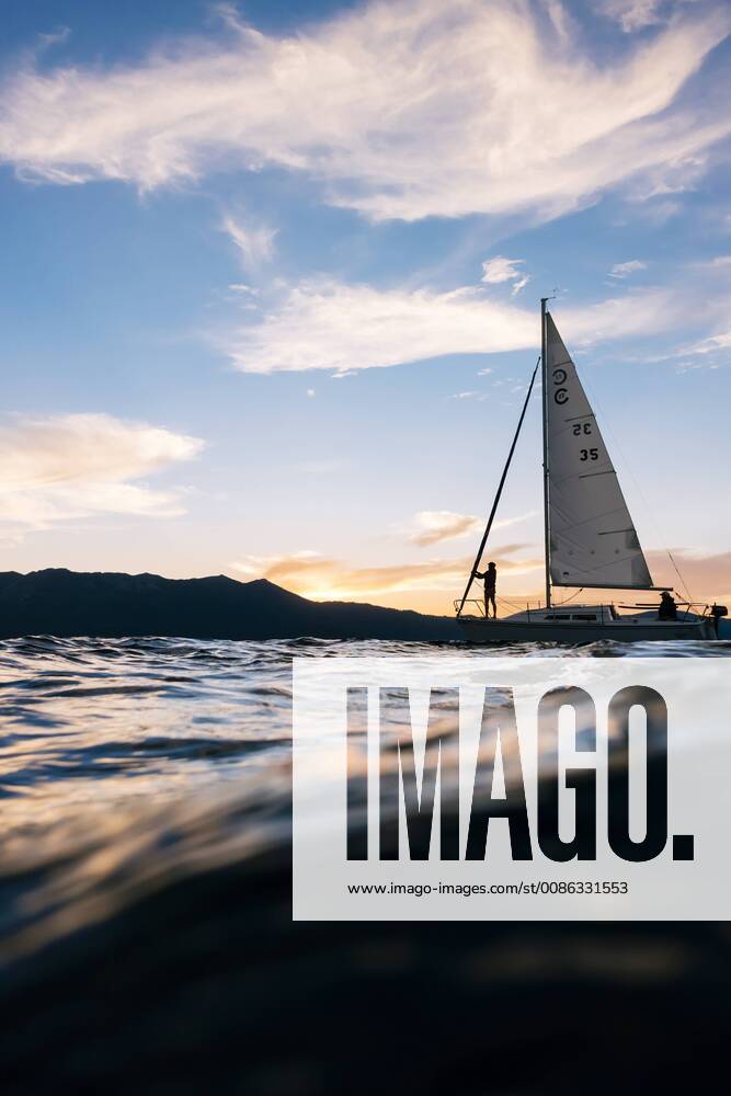 The small yacht Freshwater Cowboy is sailing on Lake Tahoe at sunset., Lake Tahoe California USA model released Symbolfoto property released