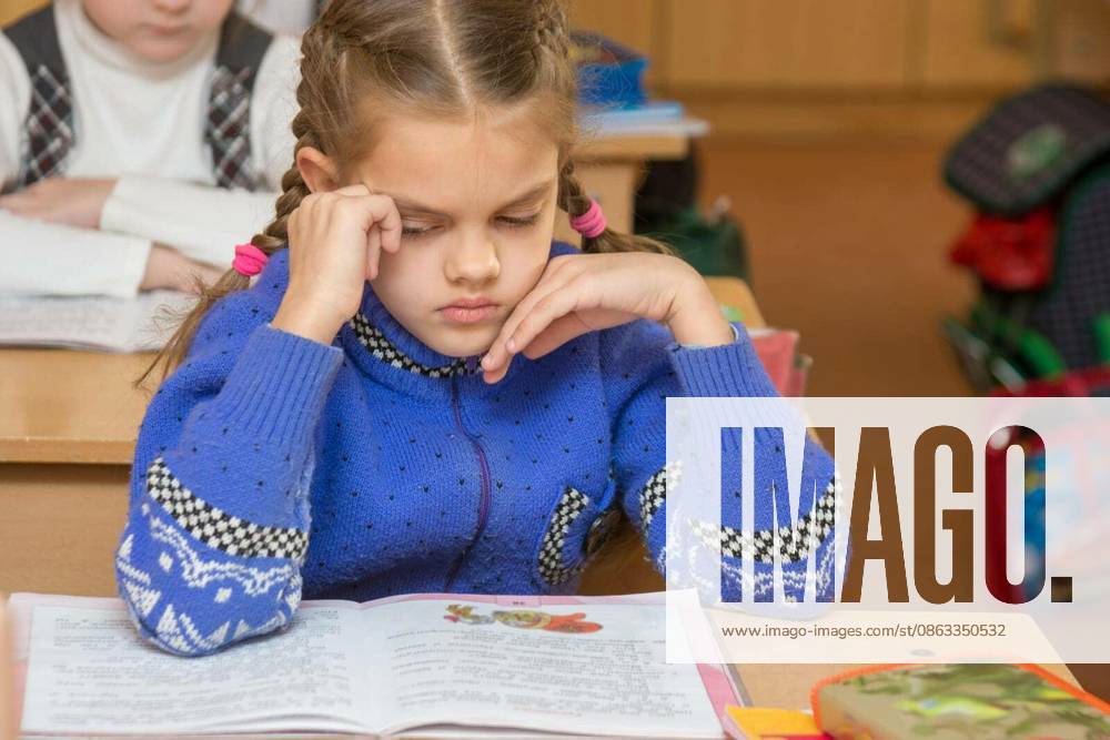 First grader girl feels bad in the classroom at school model released Symbolfoto