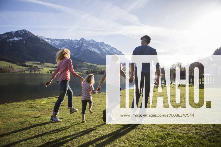 Austria, Tyrol, Walchsee, happy family walking at the lakeside model released Symbolfoto JLOF00201