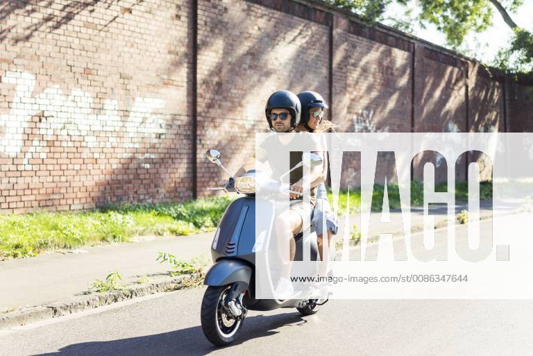 Couple riding motor scooter in summer model released Symbolfoto JOSF02604