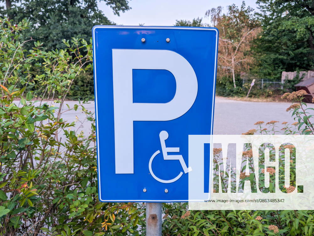 A traffic sign for a accessible parking space featuring a wheelchair symbol in a public parking lot. These designated spaces improve accessibility and enable people with disabilities to enjoy greater mobility and participate more fully in daily life