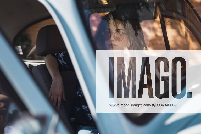 IMAGO Creative, Sommer, Schatten-Plätze bei Hitze Young woman wearing sunglasses sitting in a car model released Symbolfoto KKAF01348