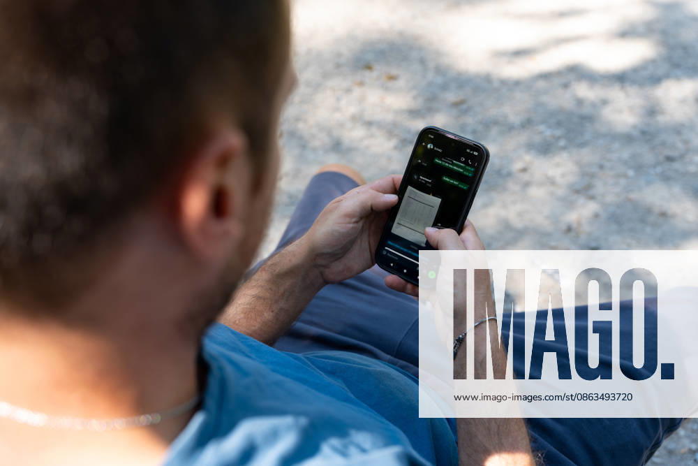 Germany, Bavaria, Munich - August 5, 2026: A person is using a messaging app on their smartphone. The image symbolizes digital communication, the rapid exchange of information, and topics such as data protection, cybercrime, and online security.