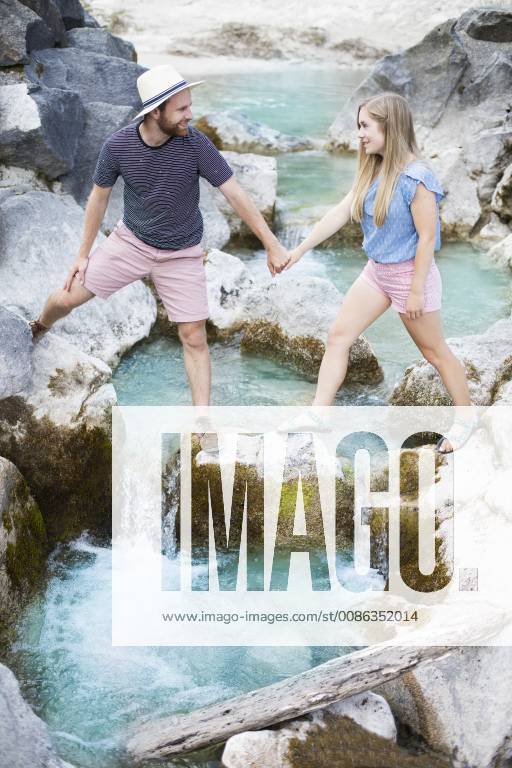 Young couple crossing river model released Symbolfoto MAEF12692