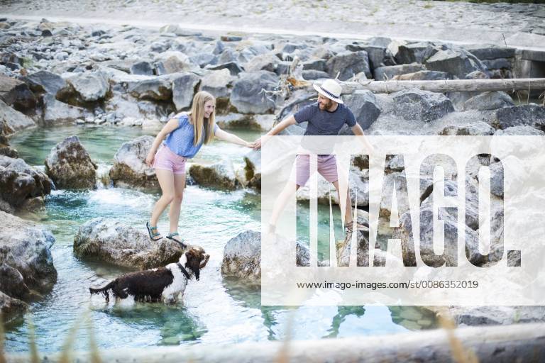 Young couple crossing river model released Symbolfoto property released MAEF12694