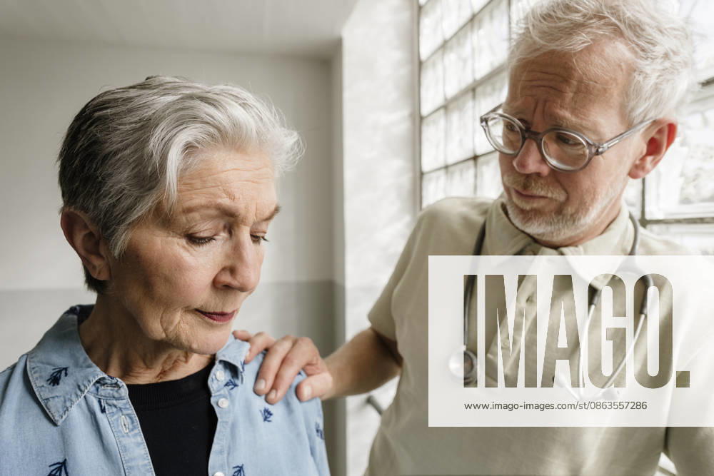 Male doctor comforts female patient after bad diagnosis indoors model released, Symbolfoto property released, KNSF12500