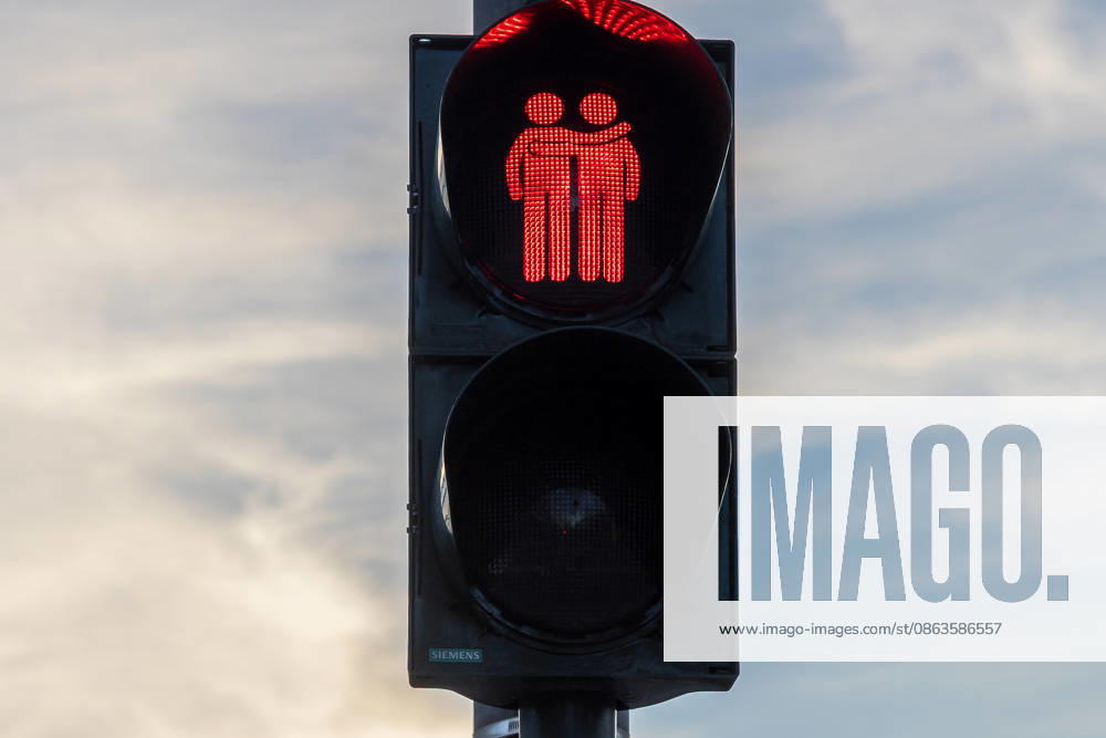 Traffic light designs featuring same-sex couples as a symbol of diversity, Erlangen, August 7, 2026 A pedestrian traffic light displays a same-sex couple in red as a symbol of diversity and tolerance. The design of the Siemens traffic light system is illuminated against a cloudy sky. Erlangen Research Center, Bavaria, Germany 20260807-286A4441-M4000