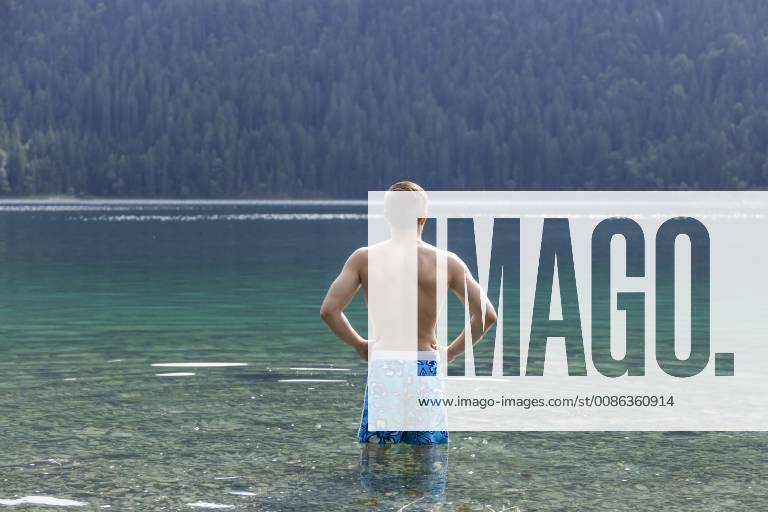 Germany, Bavaria, Eibsee, back view of young man standing in water model released Symbolfoto TCF05446