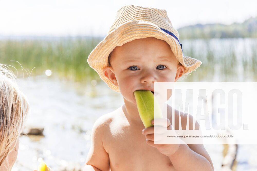Baby boy eating melon at lake model released Symbolfoto TCF05673