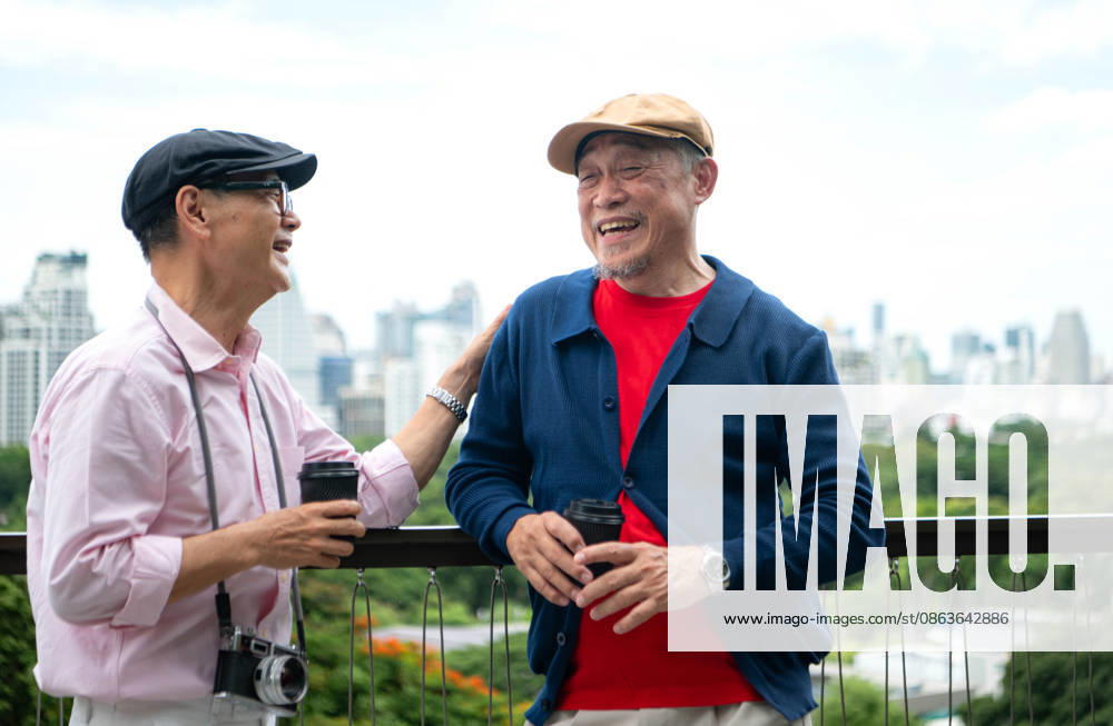 Ein älteres schwules Paar genießt Kaffee und ein Gespräch an einem Aussichtspunkt in der Stadt Senior gay couple enjoying coffee and conversation at a city viewpoint, embracing an active retirement lifestyle while exploring an urban destination (License=RF) ,model released, Symbolfoto