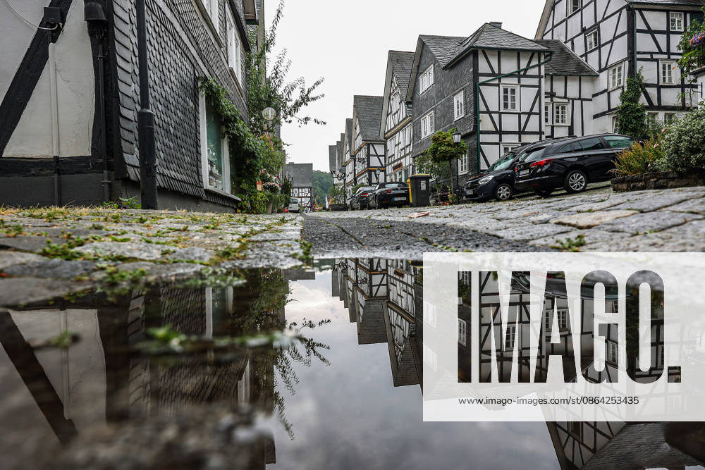 Weather Change: A rare sight in the Siegerland region in recent weeks. After days and weeks of dry, hot weather, the new week is starting off wet and relatively cool. The historic old town of Freudenberg with its half-timbered houses. The haehouses are reflected in a puddle. Summer in the Siegerland region on August 17,