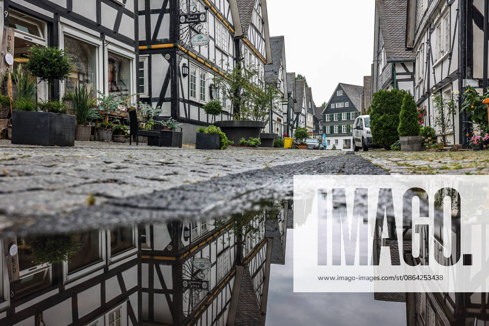 Weather Change: A rare sight in the Siegerland region in recent weeks. After days and weeks of dry, hot weather, the new week is starting off wet and relatively cool. The historic old town of Freudenberg with its half-timbered houses. The haehouses are reflected in a puddle. Summer in the Siegerland region on August 17,
