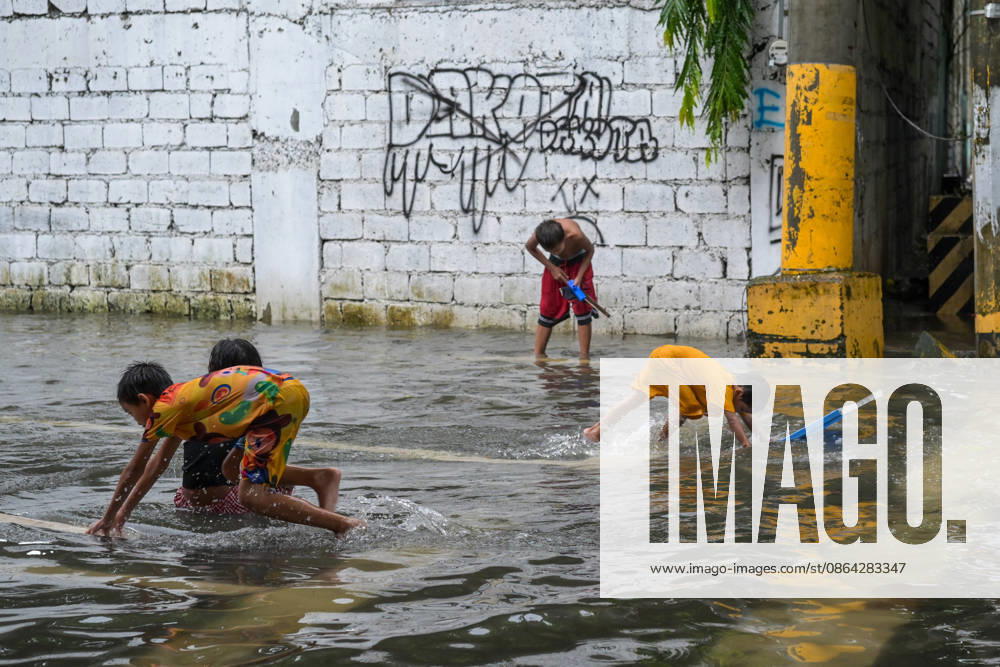 Children playing in the flood water brought by torrential monsoon rains at Qurino Ave., Manila, Metro Manila. Two days ago, Metro Manila and neighboring provinces experienced a hot and humid weather. Monsoon rain came back yesterday and persisted throughout the day with flash floods in different areas of the metropolitan. Philippines - ZUMAr240 20260817_zip_r240_060
