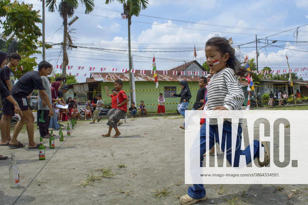Indonesia s 81st Independence Day Festive Determination - Medan Children participate in the Lomba Balap Kelereng (marble race) to celebrate Indonesian Independence Day on August 17, 2026. One girl balances a marble on a spoon in her mouth, hands behind her back, focusing on not dropping it. In the background, other children race while residents of Neighborhood IV in Karang Sari village, Medan Polonia, North Sumatra, watch the event. Photo by Aditya Sutanta ABACAPRESS.COM Medan Indonesia