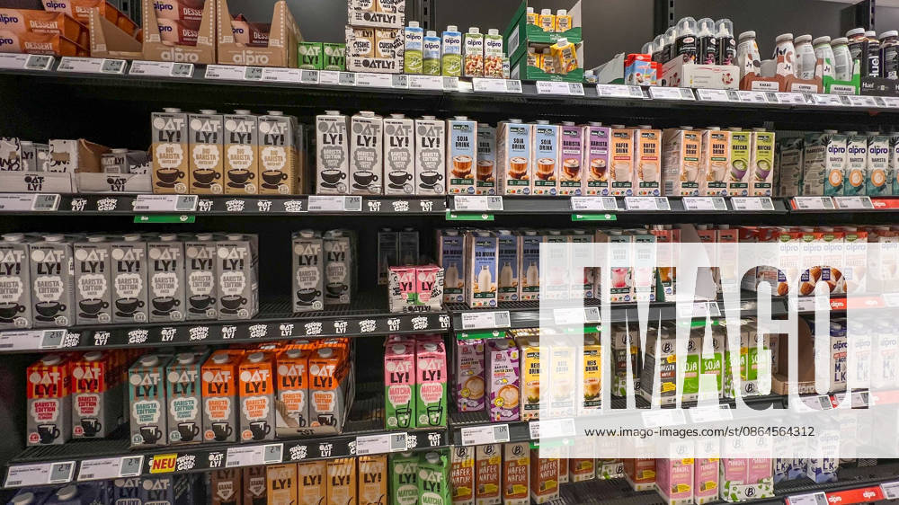 Braunschweig, Lower Saxony, Germany, Europe: A store shelf featuring plant-based milk alternatives and barista beverages in a German supermarket. Oat, soy, almond, rice, and coconut drinks from various brands are neatly arranged on refrigerated and non-refrigerated shelves with price tags; symbolic image representing vegan diets, plant