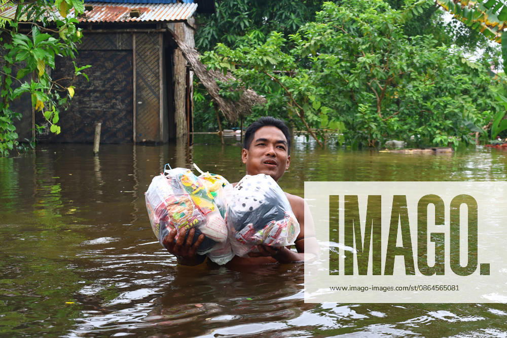 A man carries relief supplies donated by rescue teams through floodwaters to higher ground in Ngathaingchaung Township, Ayeyarwady Region, Myanmar..In Laymyethna Township, Ayeyarwady Region, the Ngawun River embankment collapsed on July 31, leaving nearby towns including Hinthada, Yegyi, Ngathaingchaung, Kyonpyaw and Kyaunggon still inundated for three weeks, affecting tens of thousands of people, officials said. Ngathaingchaung Myanmar - ZUMAn324 20260820_zip_n324_015