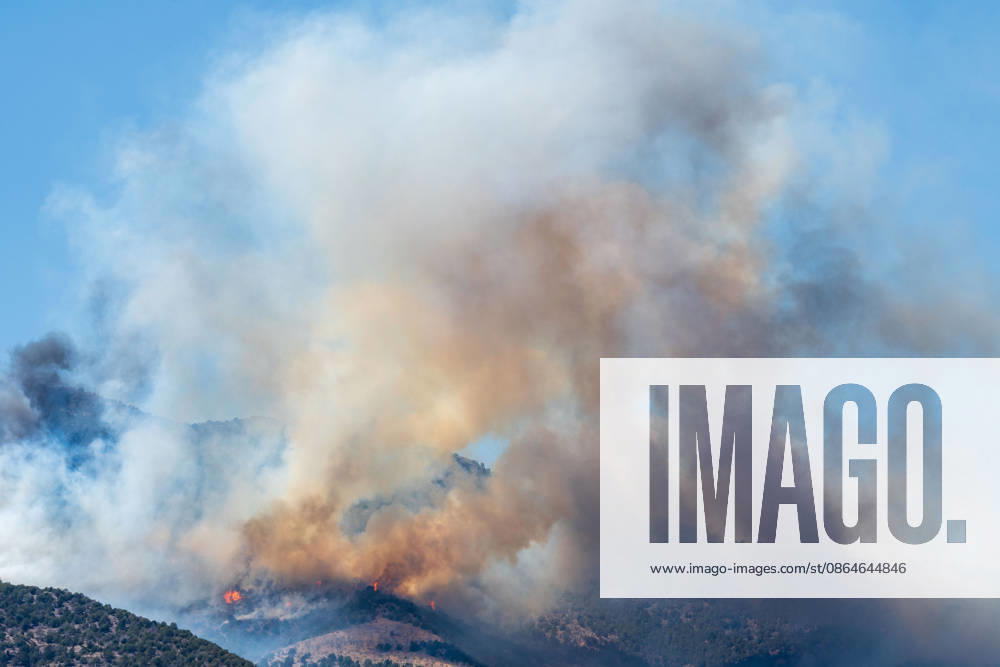 Smoke and flames are visible on a hillside as the Big Mountain Fire burns southwest of Elberta. State and local air and ground resources were deployed to fight the wildland fire, which rapidly reached an estimated 30 acres with zero containment. Elberta USA - ZUMAm292 20260823_znp_m292_019