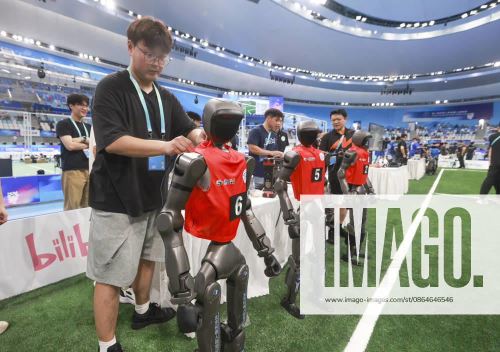 Technicians check robot players during the quarterfinal match of the soccer event - 5v5 Large Size Group on day 2 of the 2nd World Humanoid Robot Games at National Speed Skating Oval on August 23, 2026 in Beijing, China.