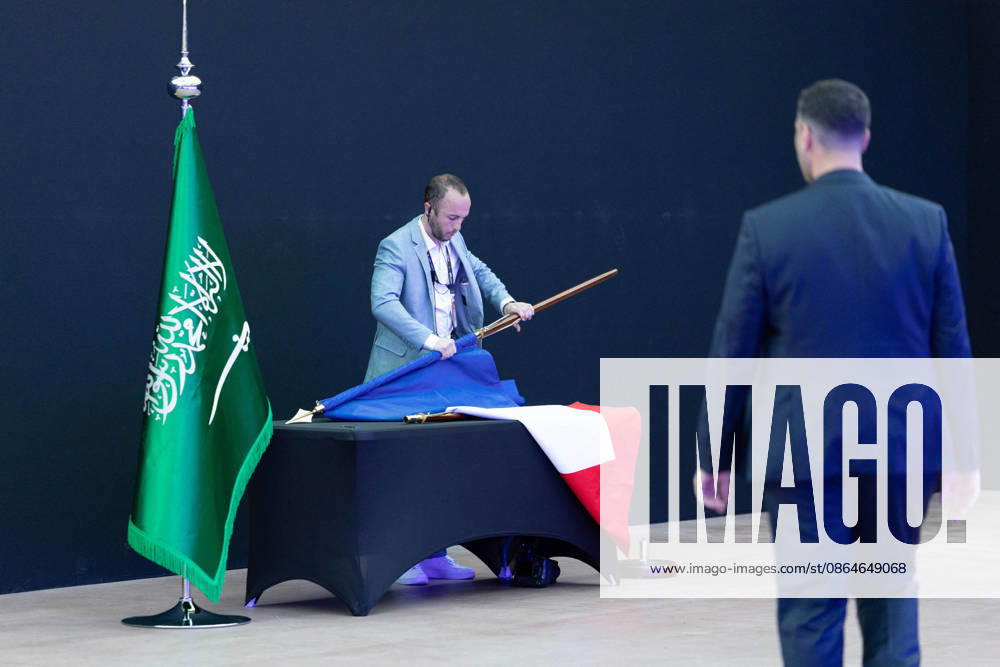 Emmanuel Macron And Mohammed Bin Salman Attend Esports World Cup Closing Ceremony - Paris A man put away a French flag next to a Saudi Arabia flag after the signing of an accord of cooperation about sports ahead of the closing ceremony of the Esports World Cup at the Grand Palais in Paris, France, 23 August 2026. Photo by Raphael Lafargue ABACAPRESS.COM Paris Ile-de-France France