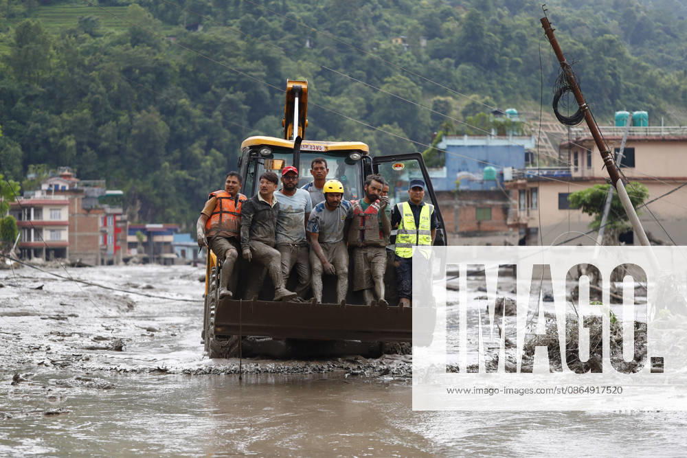 Security personnel rescue people in a dozer from buildings and infrastructure that were damaged along the swollen Trishuli River following a massive flash flood triggered by an avalanche of ice and rock in the upper Lhende River on the Tibetan side, in Nuwakot district, Nepal, on Wednesday, August 26, 2026. The sudden flood swept through communities along the Bhote Koshi and Trishuli river systems, destroying homes, roads and bridges and leaving widespread devastation downstream. Nuwakot Nepal - ZUMAg200 20260826_zap_g200_015