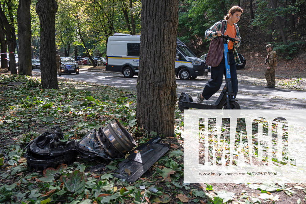 A woman pushes a rented electric scooter past the fragments of a Russian drone found on Parkova Doroha Street in the Pecherskyi district after a Russian attack, Kyiv, Ukraine, August 27, 2026. Since the night of August 27, the Russian army has been striking the Ukrainian capital with ballistic missiles and drones. Overnight and daytime attacks and falling debris caused destruction across several districts of Kyiv, damaging residential buildings, cars, gymnasium premises and a medical facility. (Photo by Danylo Antoniuk Ukrinform) Forensic experts examine wreckage of Russian drone in Kyiv