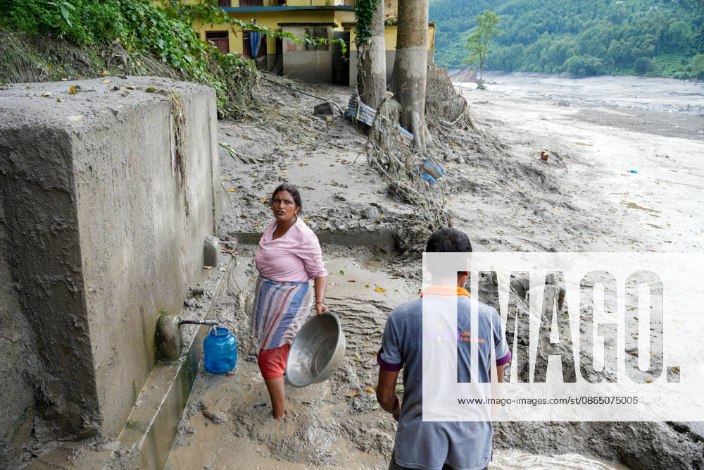 Nepal Flash Flood Leaves Hundreds Missing in Himalayan Border District A local resident cleans debris from a drinking water tap following flash floods in Devighat, Nuwakot, Nepal, on August 27, 2026. Kathmandu Nepal