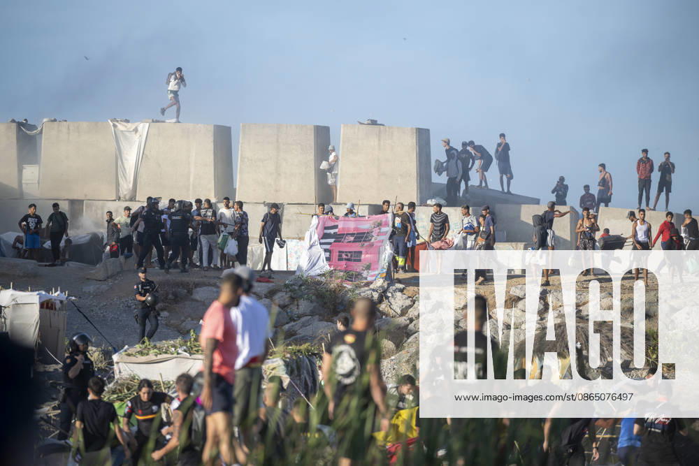Protest Against Migrants in Ceuta: Migrants on the beach during a demonstration to protest the situation caused by their mass arrival, on August 27, 2026, in Ceuta, Spain. Protesters attempted to block Red Cross volunteers from distributing food bags to migrants on Trampolín Beach and caused disturbances on Benítez Beach in Ceuta, which led to police charges, after they entered the migrant encampments where people spend the night in the area and caused damage, including the burning of personal belongings. AUGUST 27, 2026 MIGRATION CRISIS Ceuta Ceuta, Spain