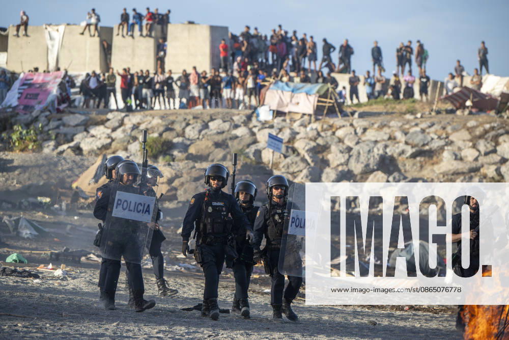 Protest Against Migrants in Ceuta: Police and migrants on the beach during a demonstration to protest the situation caused by their mass arrival, on August 27, 2026, in Ceuta, Spain. Protesters attempted to block Red Cross volunteers from distributing food bags to migrants on Trampolín Beach and caused disturbances on Benítez Beach in Ceuta, which led to police charges, after they entered the migrant encampments where people spend the night in the area and caused damage, including the burning of personal belongings. AUGUST 27, 2026 MIGRATION CRISIS Ceuta Ceuta, Spain