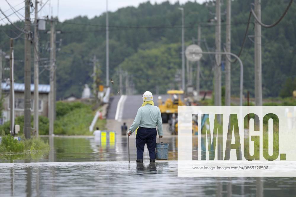 Torrential rain in central Japan A person stands on a submerged street in Himi in Toyama Prefecture, central Japan, on Aug. 28, 2026, following torrential rain. A14AA0005626749P
