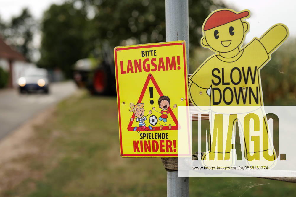 Please Slow Down—Children Playing : A warning sign reading * Please Slow Down—Childre