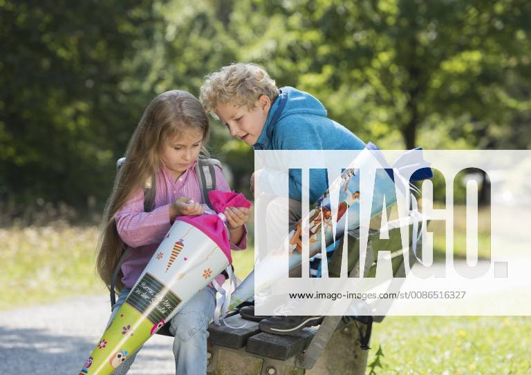Two children pack school bag from model released