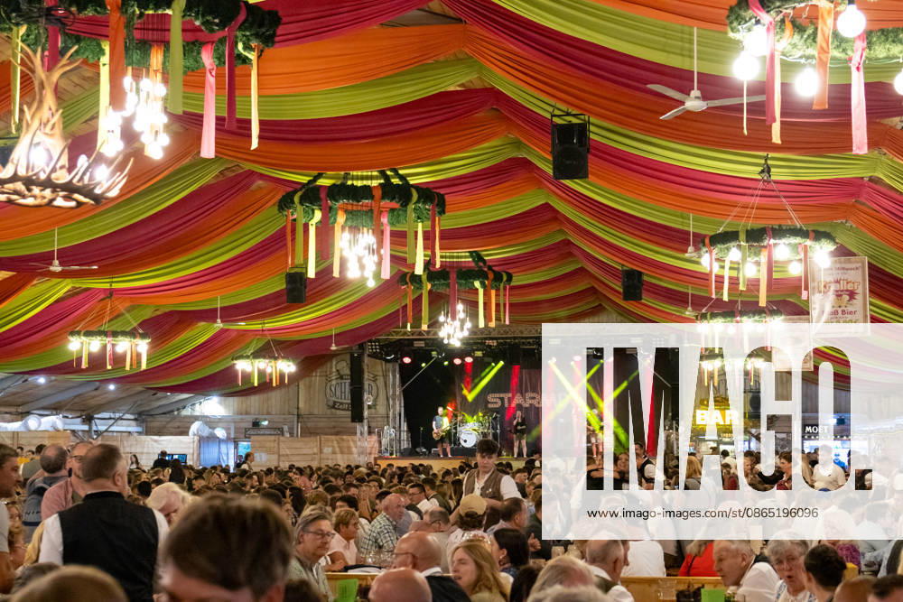 Opening of the Plärrer in Augsburg. A packed festival tent at the Augsburg Herbstplärrer. Numerous visitors celebrate in dirndls and lederhosen, drink beer, and enjoy the lively atmosphere of the traditional folk festival