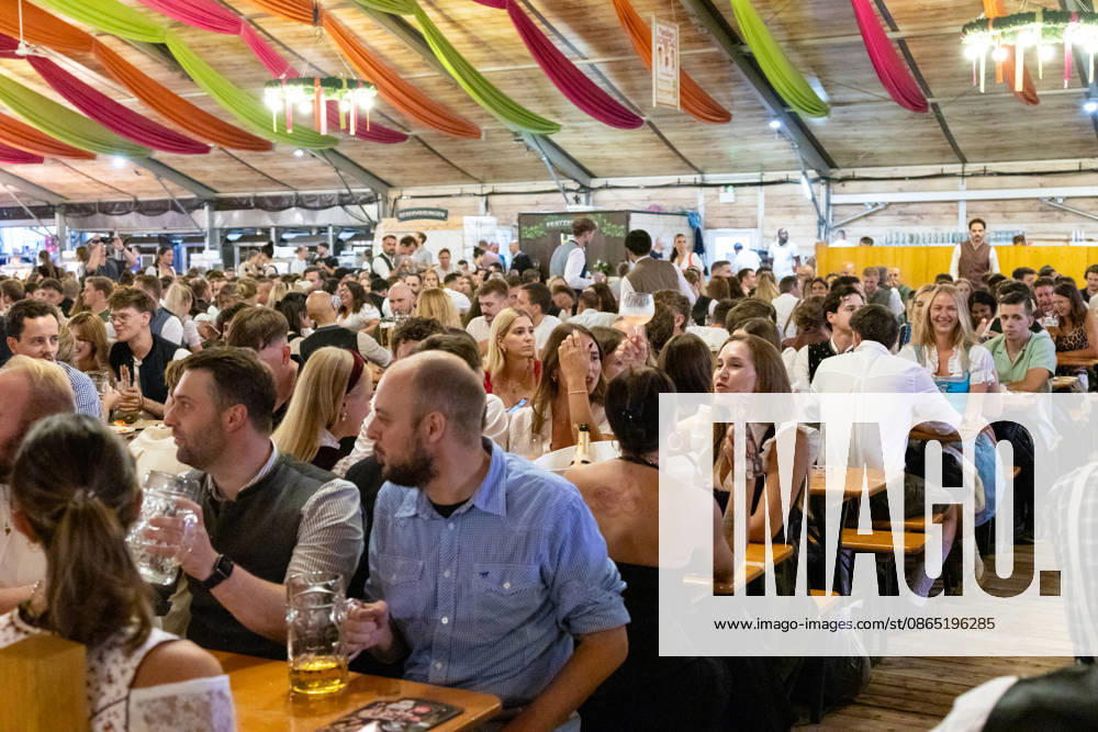 Opening of the Plärrer in Augsburg. A packed festival tent at the Augsburg Herbstplärrer. Numerous visitors celebrate in dirndls and lederhosen, drink beer, and enjoy the lively atmosphere of the traditional folk festival