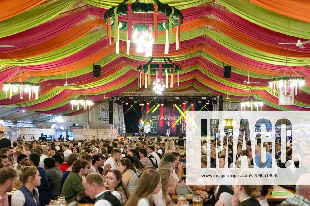 Opening of the Plärrer in Augsburg. A packed festival tent at the Augsburg Herbstplärrer. Numerous visitors celebrate in dirndls and lederhosen, drink beer, and enjoy the lively atmosphere of the traditional folk festival