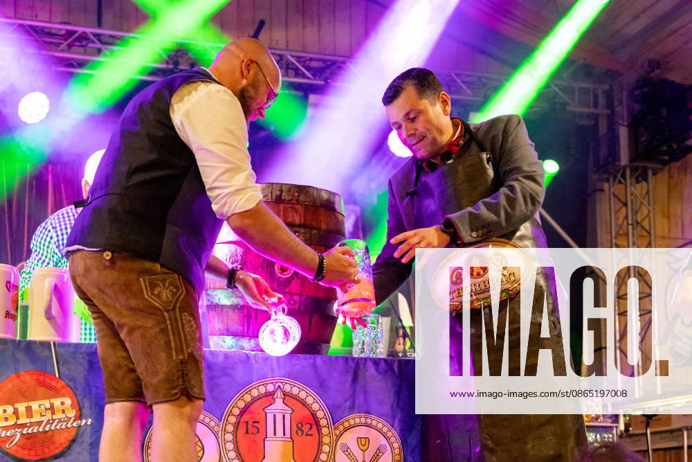 Augsburg, Bavaria, Germany August 28, 2026: Opening of the Plärrer in Augsburg. After the traditional tapping of the keg, free beer is served at the Augsburg Herbstplärrer. Visitors hold out their beer mugs toward the stage and have beer poured directly from the keg
