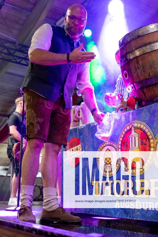 Augsburg, Bavaria, Germany August 28, 2026: Opening of the Plärrer in Augsburg. After the traditional tapping of the keg, free beer is served at the Augsburg Herbstplärrer. Visitors hold out their beer mugs toward the stage and have beer poured directly from the keg