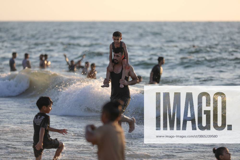 Nuseirat, Palestine, State of: NUSEIRAT, GAZA STRIP, PALESTINE, AUGUST 2026: Palestinians gather along the beach in Nuseirat seeking relief from the summer heat as high temperatures add to difficult living conditions for displaced families staying in tents. Residents spend time by the sea as a respite from the heat and the hardships of daily life in the Gaza Strip. Nuseirat Palestine, State of - ZUMAq101 20260829_zna_q101_023
