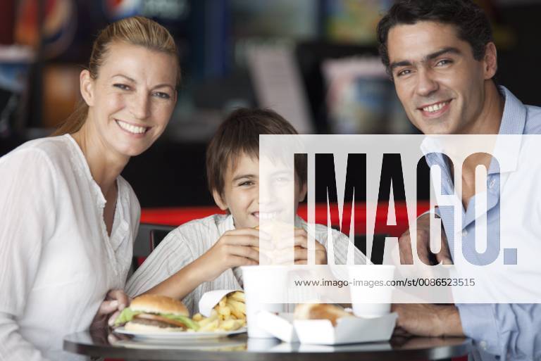 Family eating together in fast food restaurant, portrait