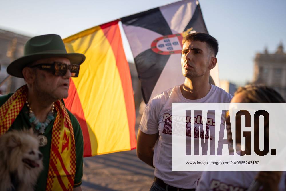 A man wearing a t-shirt from the far-right group Revuelta stands in front of a Ceuta flag and a Spanish flag during a rally in Madrid.Rally organized by far-right groups such as Europe Save Act, Revuelta, and Reconquista in support of remigration, under the slogan Save Spain, save Europe! Madrid Spain - ZUMAs197 20260829_aaa_s197_144