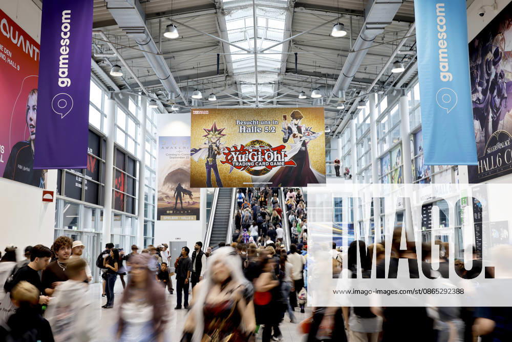Visitors stream into Gamescom 26, the world s largest video game trade show, at Koelnmesse, passing under an advertisement for the video game Yu-Gi-Oh! Thematic image, stock photo; Cologne, August 30, 2026; North Rhine-Westphalia, Germany