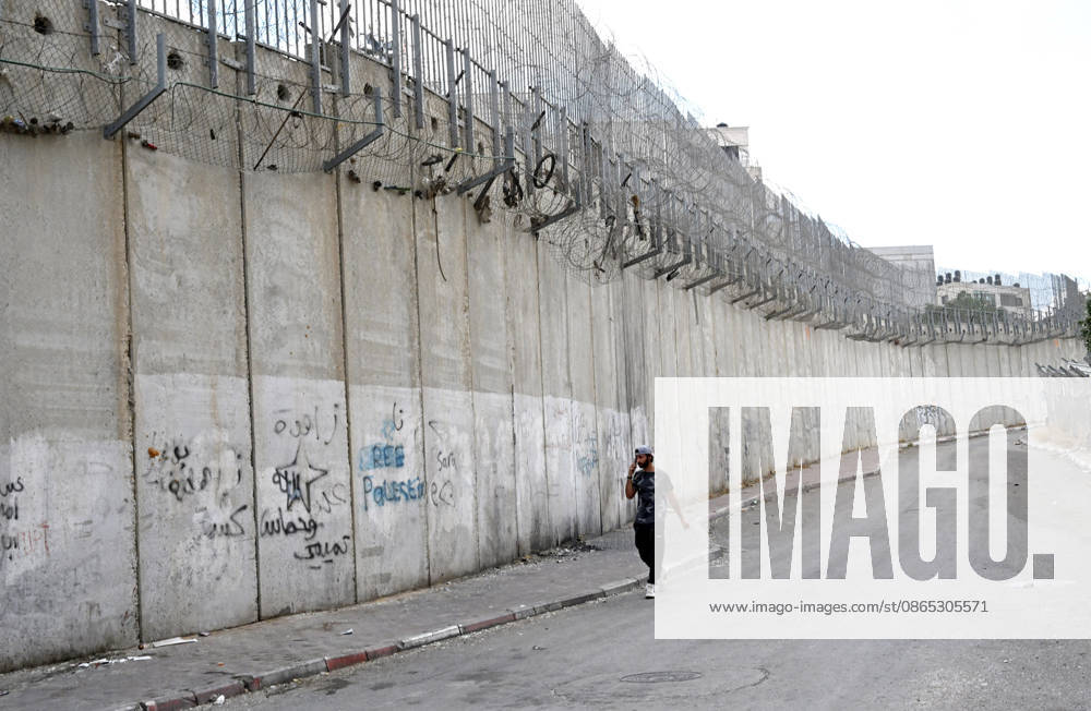 A Palestinian walks beside the Israeli separation wall that cuts through Beit Hanina in East Jerusalem on Sunday, August 30, 2026. Thousands of Palestinian residents of East Jerusalem are forced to go through time consuming checkpoints to reach their schools, jobs, hospitals and visit family because of the separation barrier. JER2026083005 DEBBIExHILL