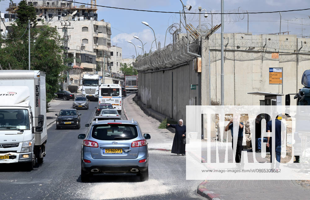 A Palestinian woman tries to flag a ride beside the Israeli separation wall that cuts through Beit Hanina in East Jerusalem on Sunday, August 30, 2026. Thousands of Palestinian residents of East Jerusalem are forced to go through time consuming checkpoints to reach their schools, jobs, hospitals and visit family because of the separation barrier. JER2026083010 DEBBIExHILL
