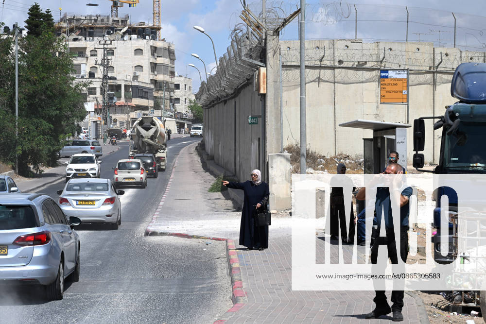 A Palestinian woman tries to flag a ride near the Israeli separation wall that cuts through Beit Hanina in East Jerusalem on Sunday, August 30, 2026. Thousands of Palestinian residents of East Jerusalem are forced to go through time consuming checkpoints to reach their schools, jobs, hospitals and visit family because of the separation barrier. JER2026083011 DEBBIExHILL