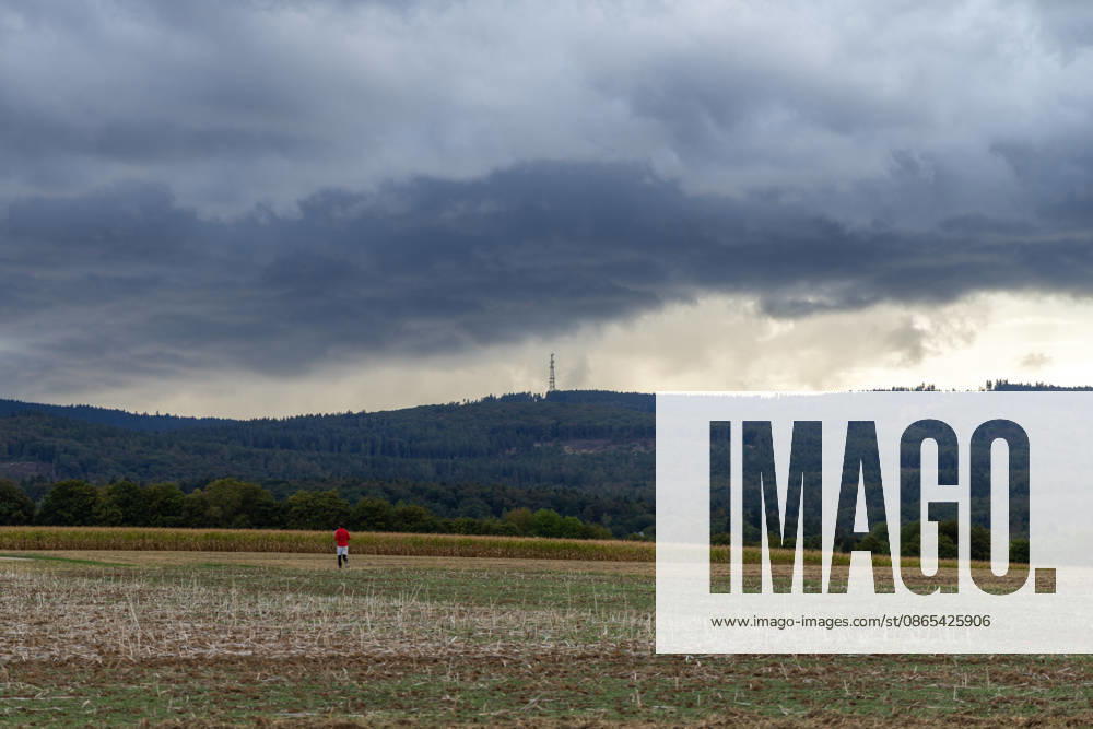Showery weather in late summer: Dark clouds from a shower are visible in the evening sky over the Taunus Mountains, Oberursel, Hesse, Germany