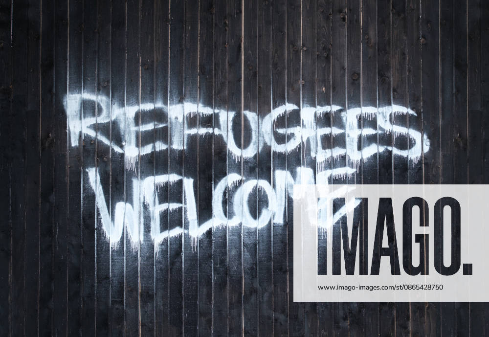 Schild ?Flüchtlinge willkommen? im Vereinigten Königreich Refugees Welcome Message Painted On Wooden Fence In Britain (License=RF)