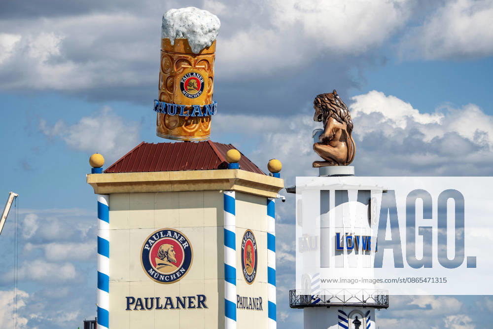 Oktoberfest 2026, The Paulaner and Löwenbräu towers already dominate the white-and-blue Bavarian sky above the Theresienwiese, three weeks before Oktoberfest begins on September 19, Munich, August 31, 2026, Germany, Munich, August 31, 2026, Oktoberfest 2026: The Paulaner and Löwen