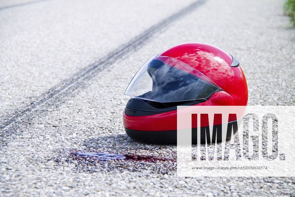 Ein Unfall mit Motorrad. Verkehrsunfall mit Bremsspur auf Straße Symbolfoto, Motorradhelm A motorcycle accident. Traffic accident with skid mark on road symbolic photo, motorcycle helmet