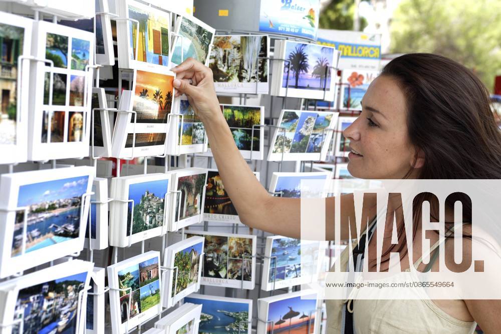 Frau vor Ansichtskartenständer auf Mallorca, Ansichtskarten, Souveniers Woman standing in front of a postcard stand on Majorca, postcards, souvenirs