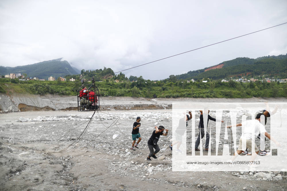 People ride on a traditional twin to get across the swollen Trishuli River following devastating flash floods that swept through the area in Nuwakot, Nepal, on Friday, September 4, 2026. The floods have left 1,287 people dead and 5,083 missing, while 13,093 people have been rescued as search and rescue operations continue. Nuwakot Nepal - ZUMAg200 20260904_zap_g200_001
